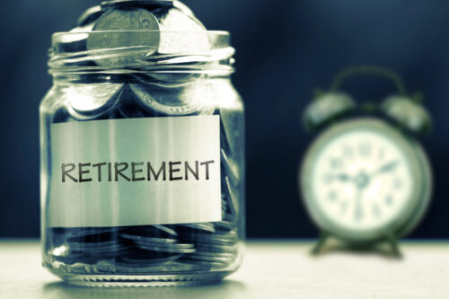 retirement coins in a jar in front of a clock