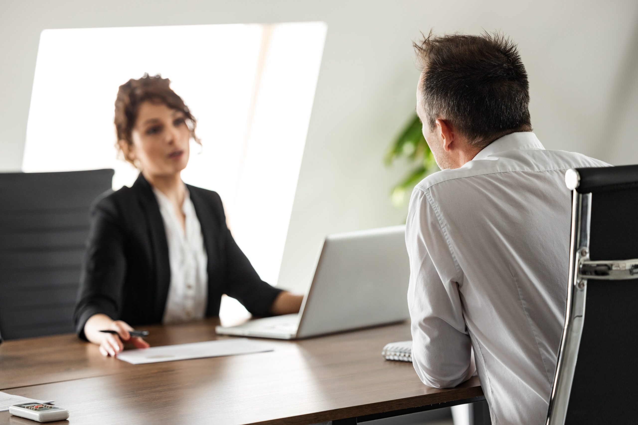 lawyer talking to client at desk sitting across from each other