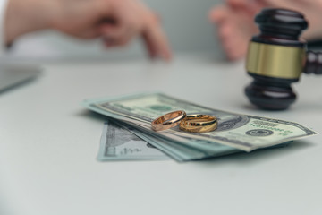 wedding rings on top of money with gavel