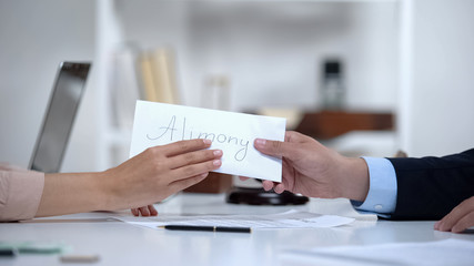 person handing off envelope labeled alimony