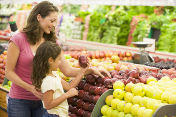 mom and child picking food out at produce section