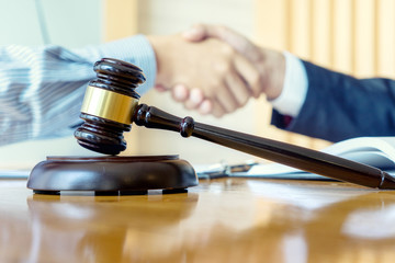 gavel with people shaking hands in background