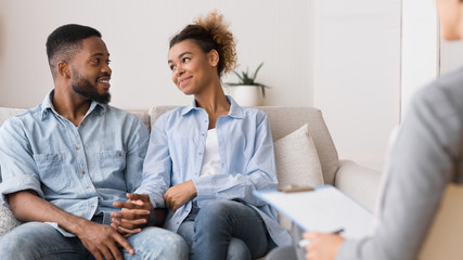 couple smiling at each other with therapist in foreground