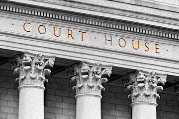 The image shows the exterior of a courthouse with large stone columns and the words "COURT HOUSE" engraved above them in capital letters, evoking the formal setting needed if you can't modify custody without court involvement.